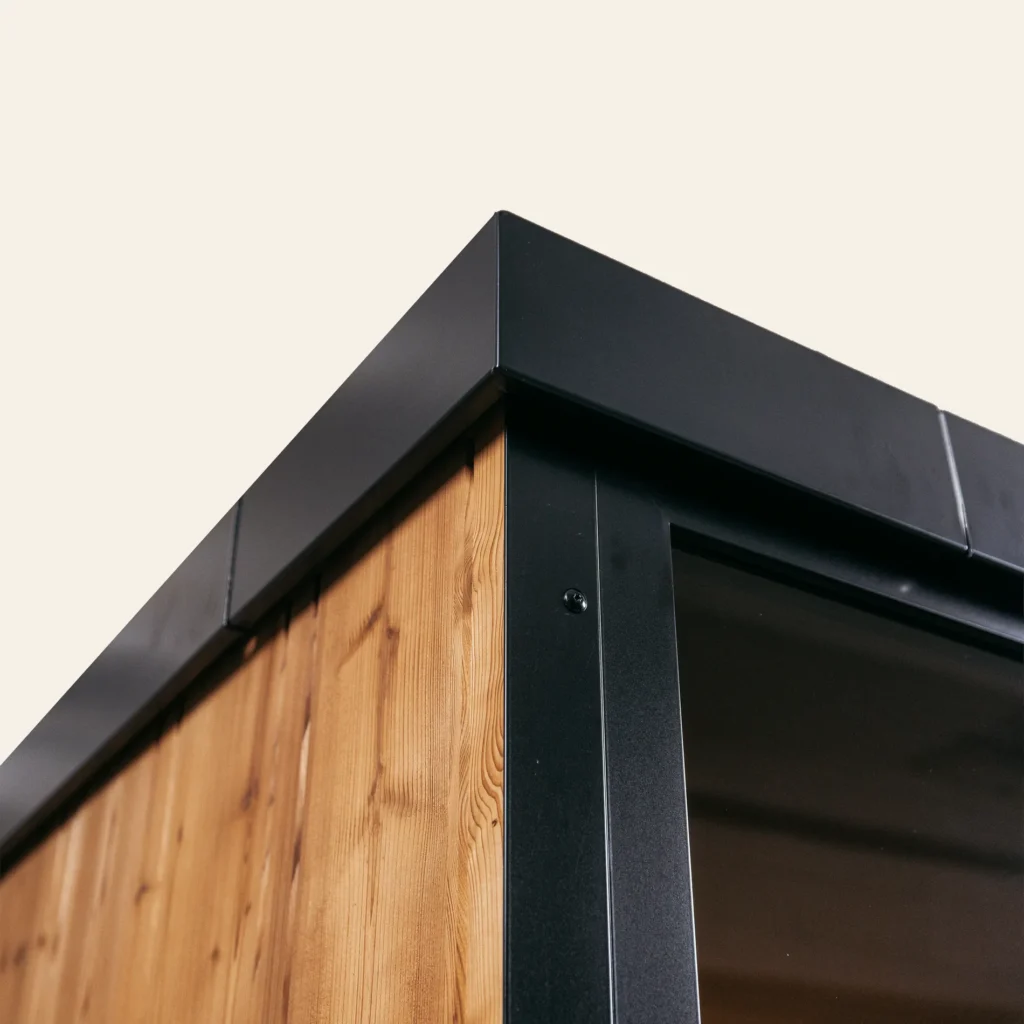 Black aluminium roof verge over the natural thermo spruce wall of the OneEighty Large Outdoor sauna
