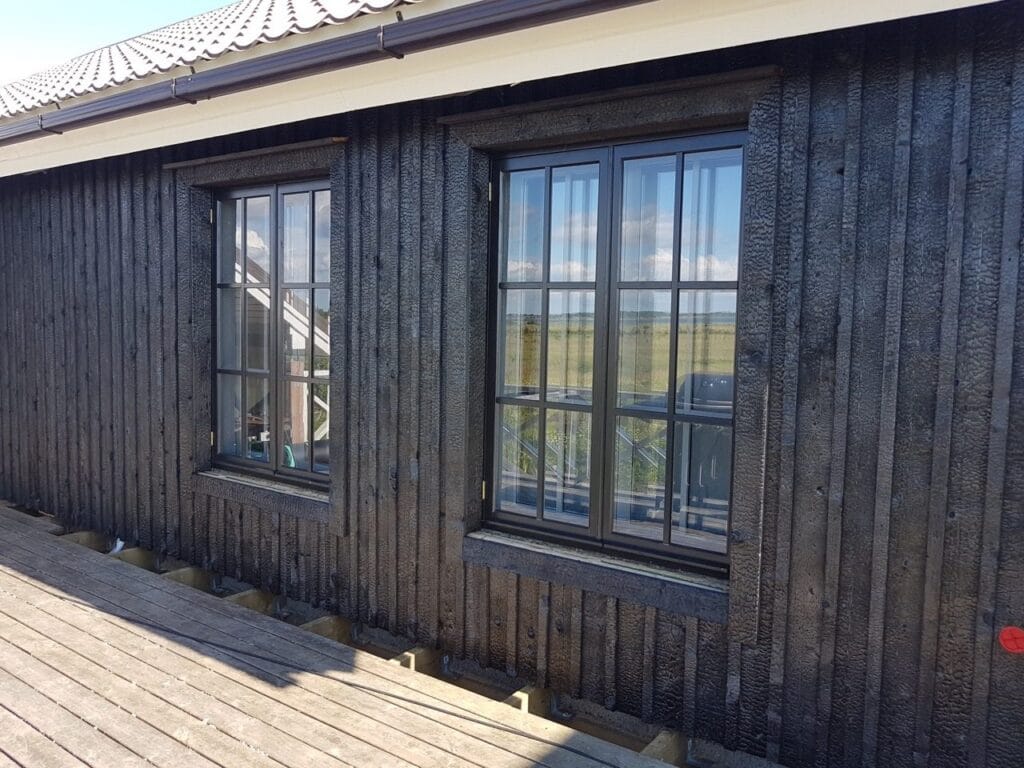 Charred yakisugi cladding beside a weathered steel panel